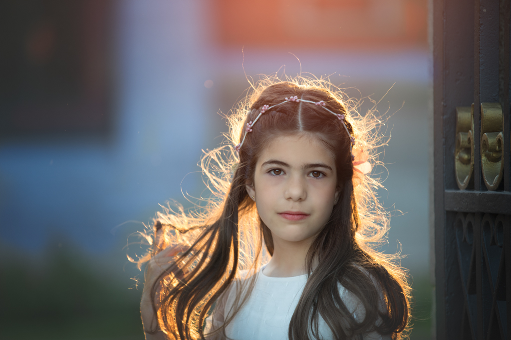 foto de niña con pelo largo y contraluz el dia de su reportaje de primera comunión en exteriores
