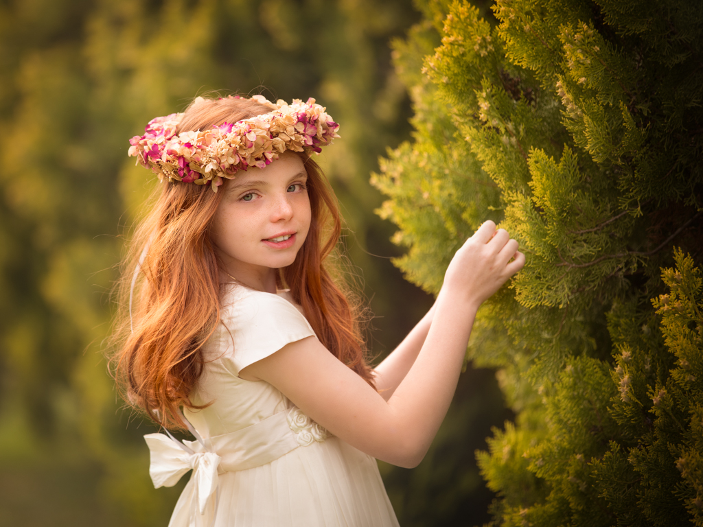 foto de niña pelirroja en vestido blanco el día de su reportaje de primera comunión en exteriores