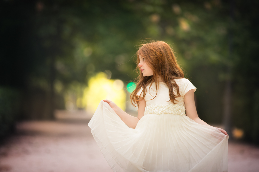 foto de niña pelirroja en vestido blanco el día de su reportaje de primera comunión en exteriores