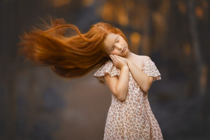 una foto artística de niña pelirroja con pelo volando