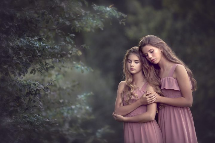 una foto de hermanas en vestido rosa en un bosque