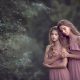 una foto de hermanas en vestido rosa en un bosque