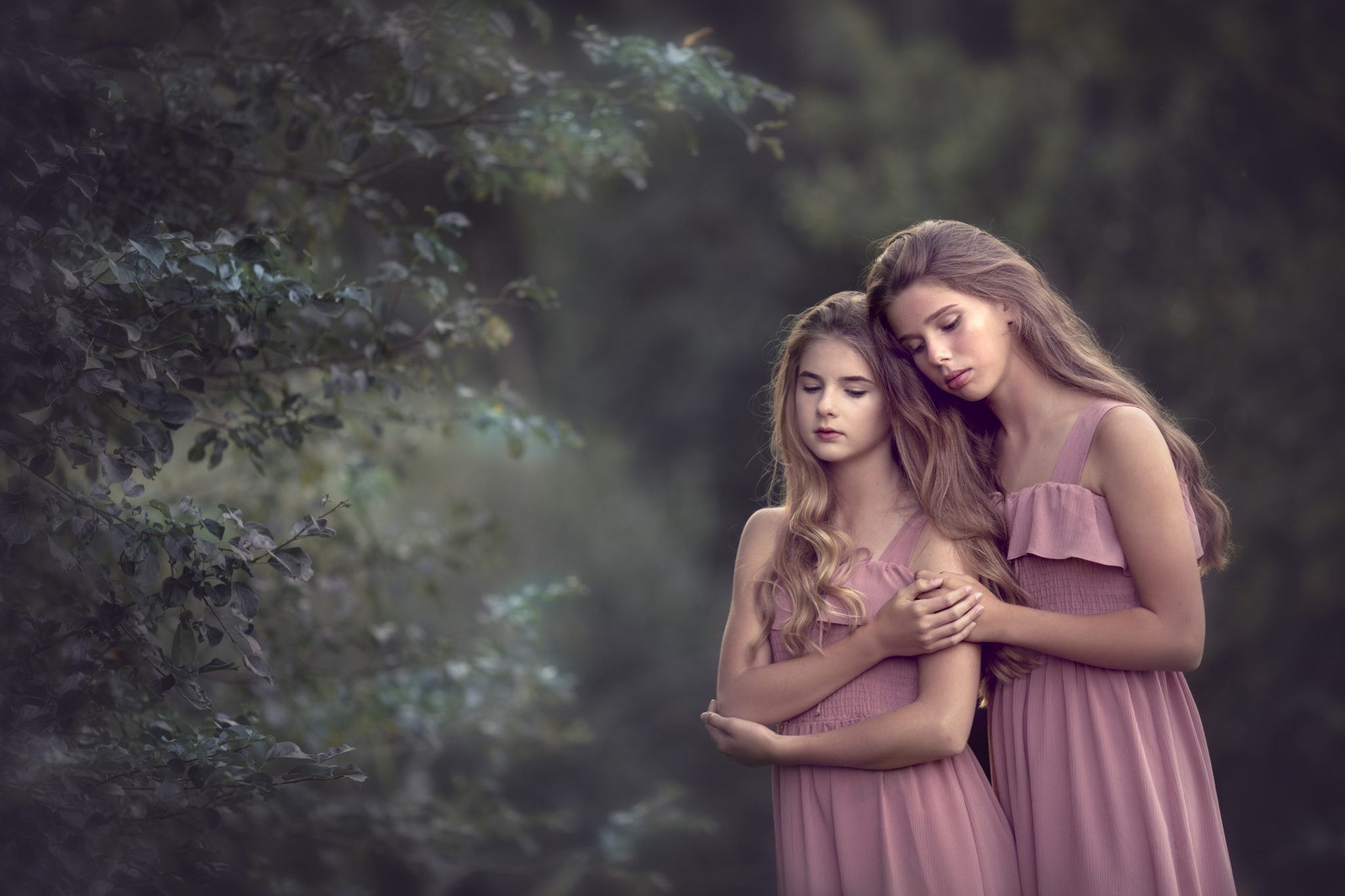 una foto de hermanas en vestido rosa en un bosque