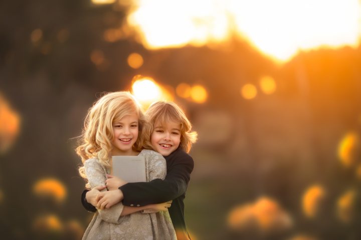 una niña rubia con hermano en traje de comuniones en reportaje fotográfico en exteriores