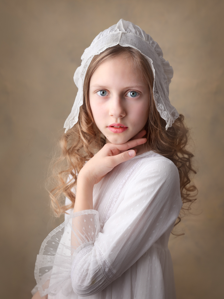 una foto de niña en vestido blanco de comunión en el estudio en Madrid