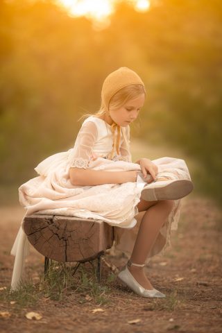 fotografia de una niña con vestido de comunión en el campo