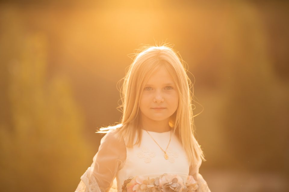 foto de niña rubia al atardecer en una sesion fotografica de primera comunión en exteriores en Madrid