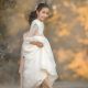 una foto de niña en vestido de primera comunión con lazo rosa y bailarinas rosa
