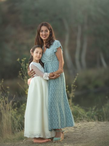 una madre y hija en vestido blanco de comunión durante una sesion de fotos en exteriores