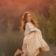 una Fotografía de niña feliz en su vestido de primera comunión al atardecer en el campo
