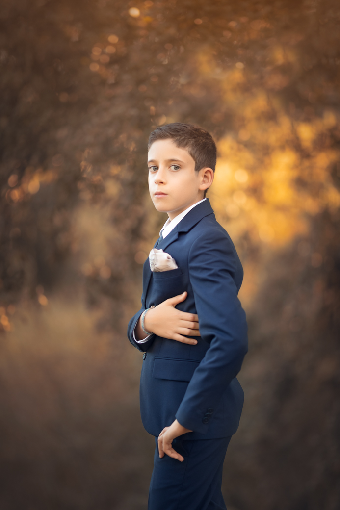 un varon en un traje elegante de primera comunión al atardecer en exteriores de madrid