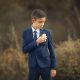 un varon en traje de primera comunión en una sesion fotografica en exteriores