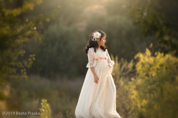 foto de nina en vestido blanco de primera comunión jugando en exteriores