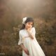 una foto tierna de una ninia en vestido de primera comunión en exteriores