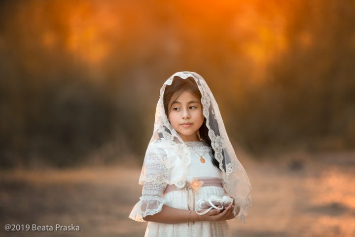 una foto de ninia de primera comunión en exteriores con luz del atardecer