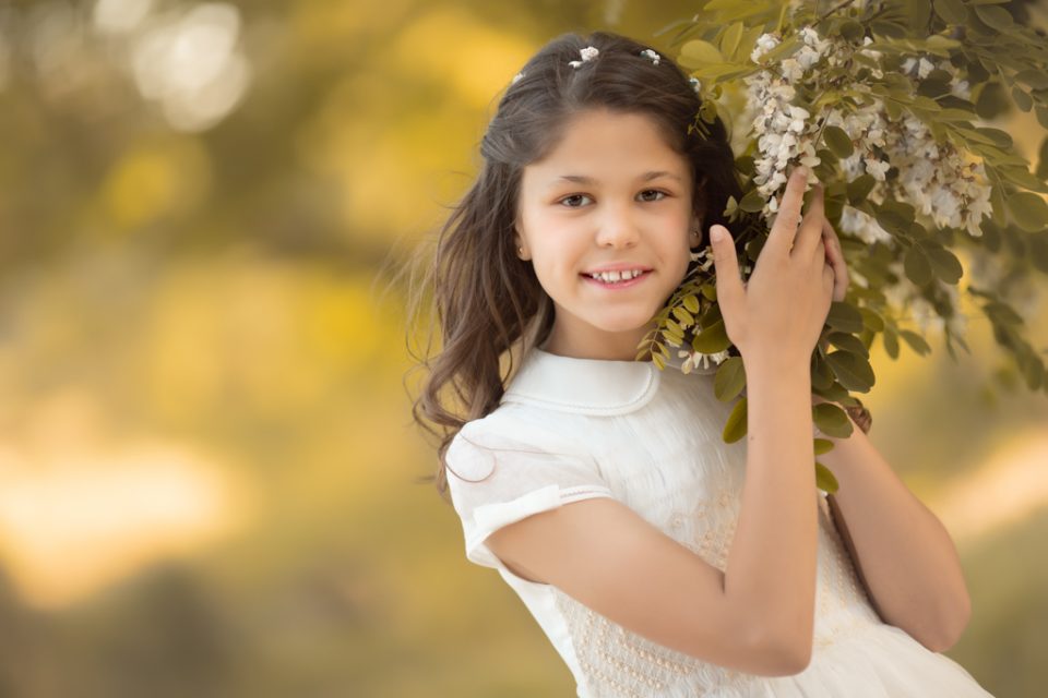 foto de niña en vestido de primera comunión en el campo al atardecer