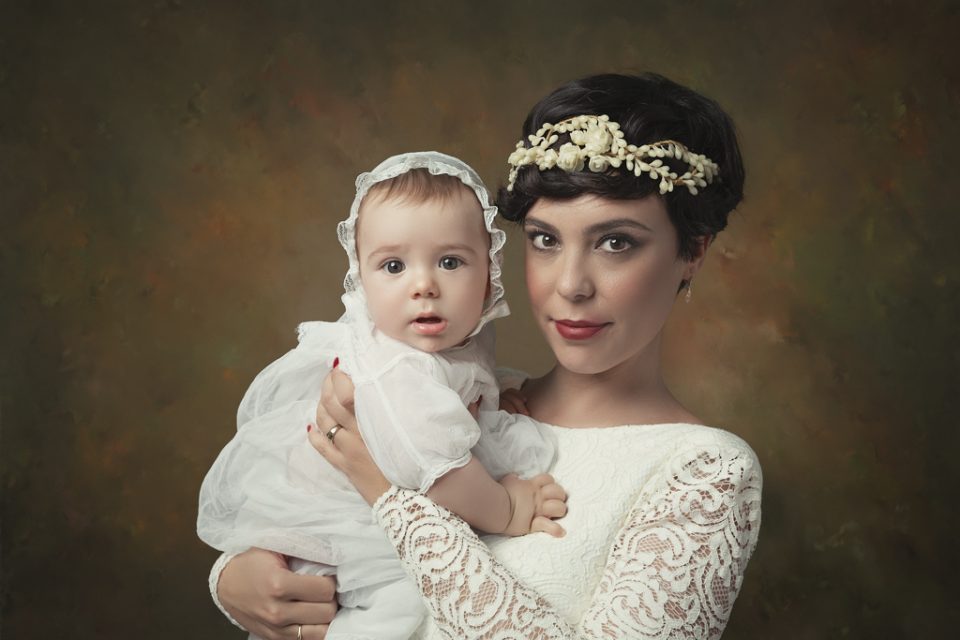 foto de mujer en vestido de boda y bebe en traje de bautizo
