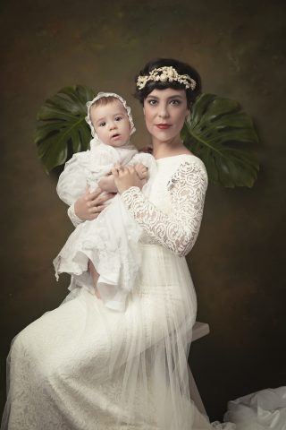 foto de mujer en vestido de boda y bebe en traje de bautizo