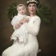 foto de mujer en vestido de boda y bebe en traje de bautizo