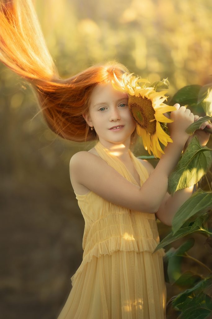 Ninia pelirroja en un campo de girasoles