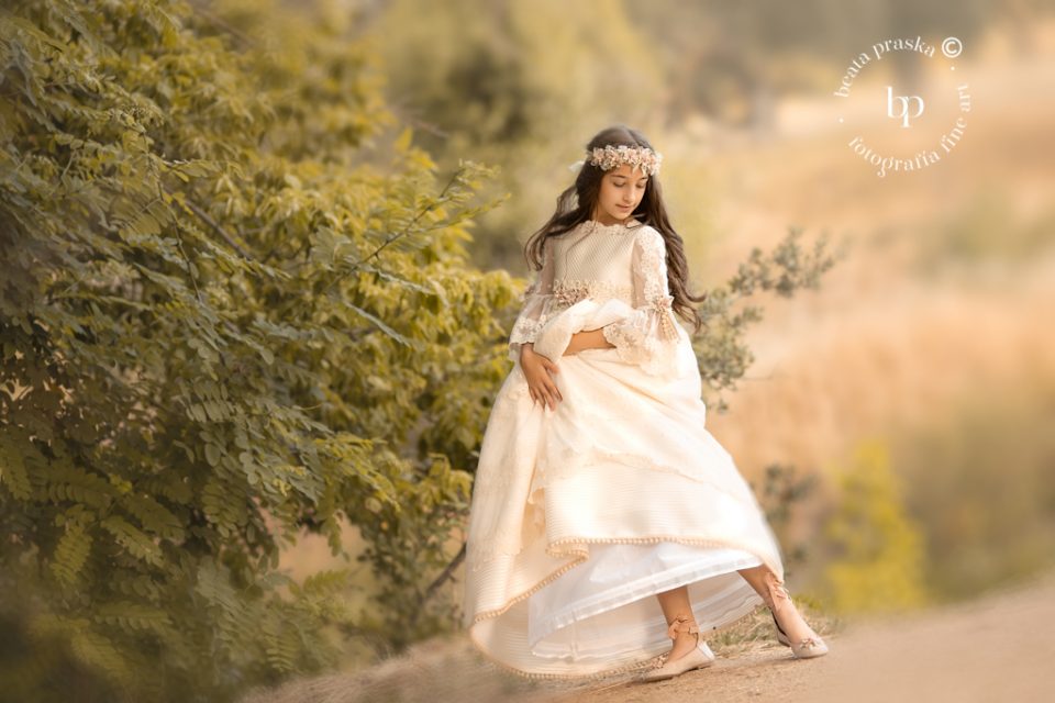 una niña en traje de comuniones fotografiada en exteriores por Beata Praska