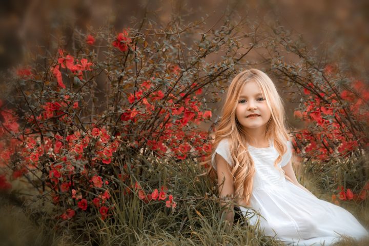 una foto de ninia rubia en vestido blanco en sesion fotografica de primera comunión en exteriores