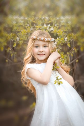 una foto de ninia rubia en vestido blanco en sesion fotografica de primera comunión en exteriores