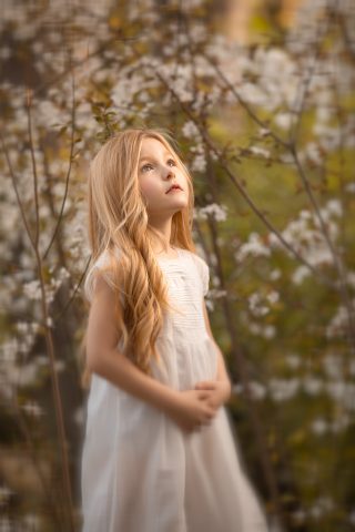 una foto de ninia rubia en vestido blanco en sesion fotografica de primera comunión en exteriores