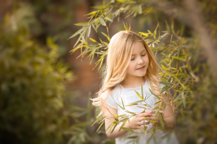 una foto de ninia rubia en vestido blanco en sesion fotografica de primera comunión en exteriores