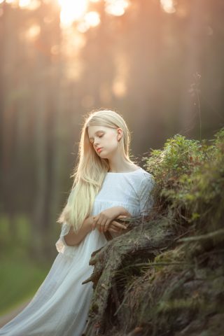 imagen de niña rubia con pelo largo y vestido blanco de primera comunión en una sesion de fotos en exteriores